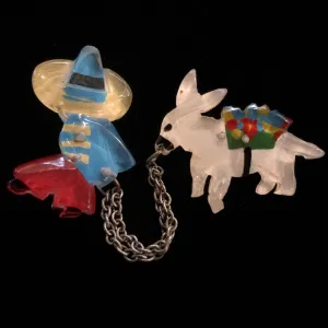 A 1940s VINTAGE LUCITE MEXICAN AND MULE BROOCH